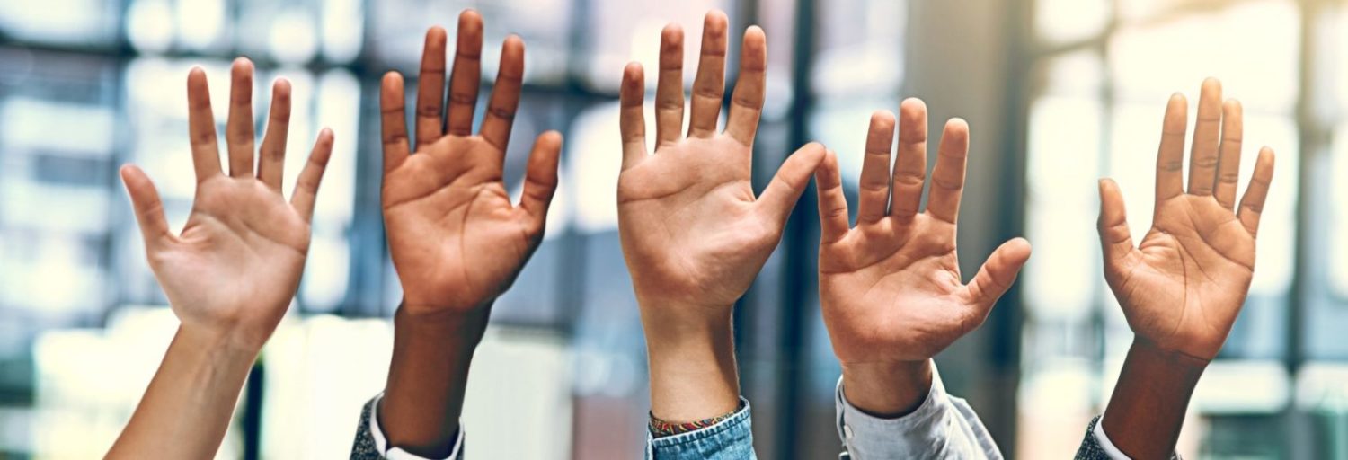 Cropped shot of a group of people raising their hands