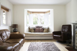 A bright and airy living room with a bay window seat and wooden floor.