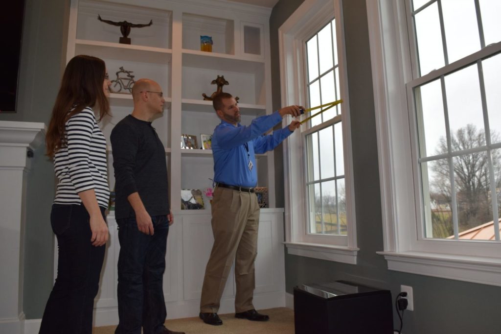 SalesRep Window Nation Exterior Design Consultant measuring windows in a customers home