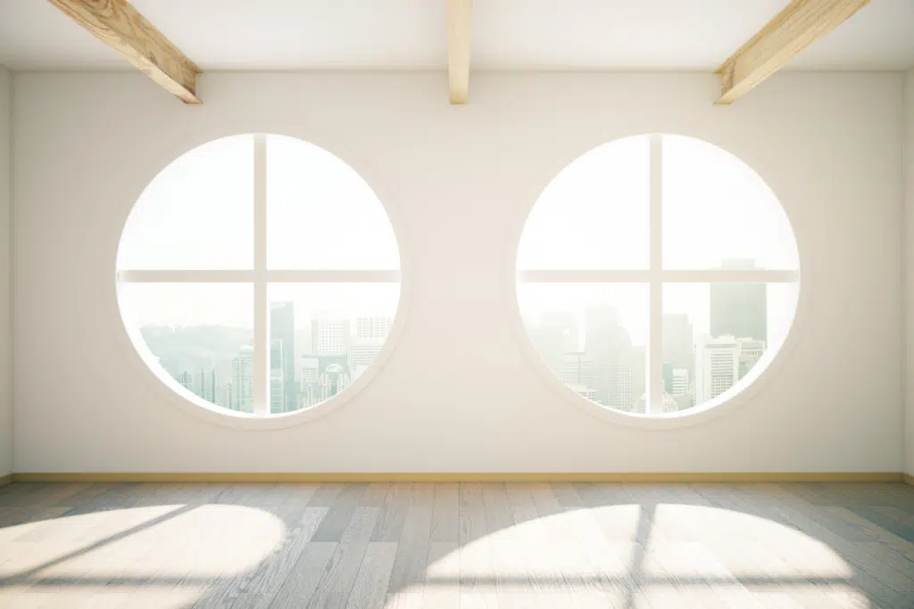 circle windows showing a view of a city in a building with white walls