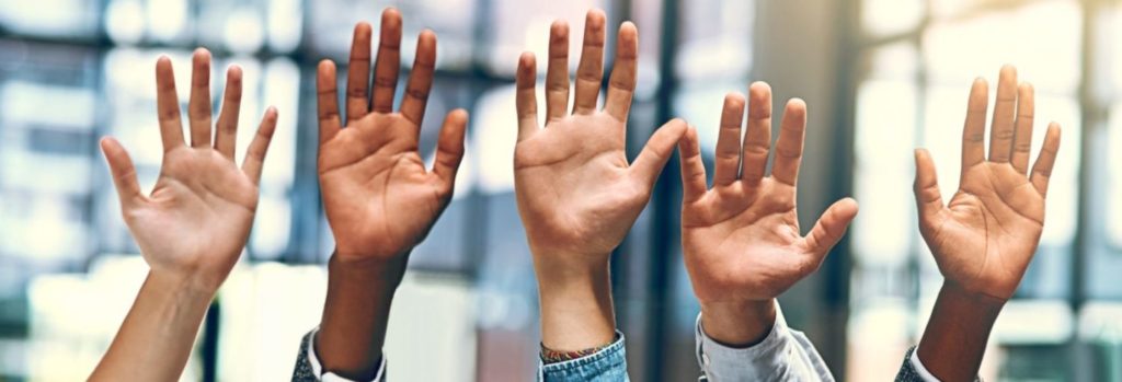 Cropped shot of a group of people raising their hands