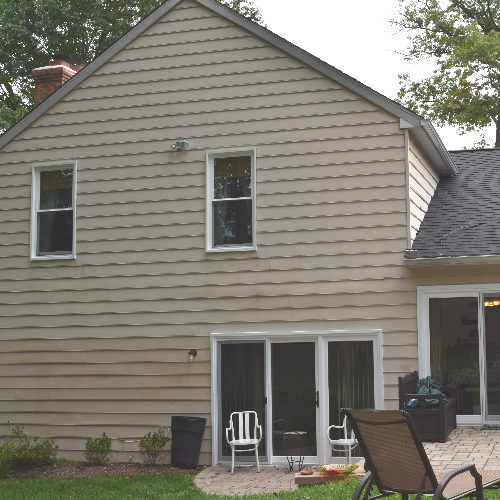 Exterior of home with windows and sliding glass door