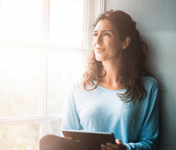 Women with Tablet looking out window