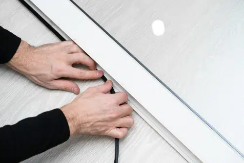person adding adhesive for window insulation