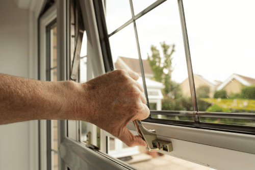 person closing and locking an open window