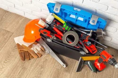 tool box overflowing with tools, gloves, and a hat