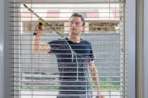 man cleaning the outside of a window with a squeegee