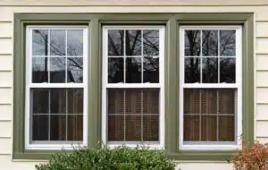 windows with green frames on a cream colored house
