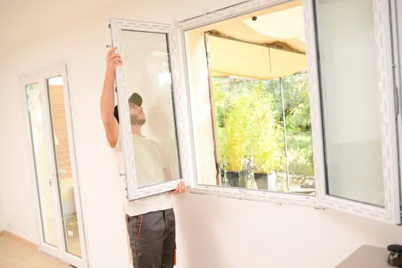 man installing a window in a home