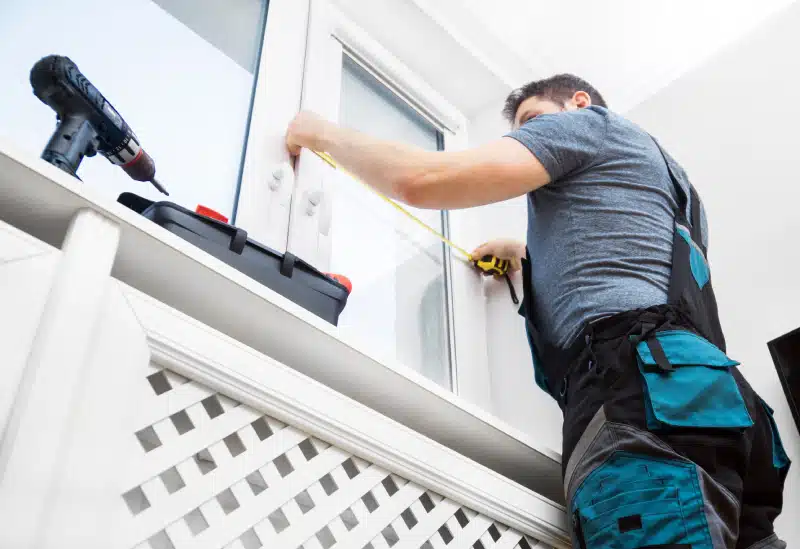 Professional installing a window into a house