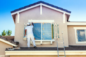 Man painting trim and shutters of after new window installation