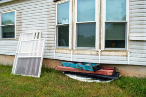 New windows sitting outside of a home waiting to be used as replacement windows