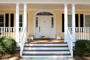 Yellow house with a big white door and a transom window